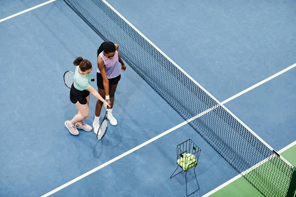 ブルーコートフロア コピースペースに対するクライアントとの作業女性テニスコーチの最小トップビュー — ストック写真