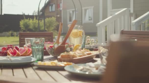 在阳光明媚的日子 没有人在自家院子里用新鲜水果和蔬菜装饰过的木制午餐桌 — 图库视频影像