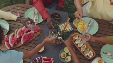 Tanımlanamayan siyahi bir kadının açık hava öğle yemeği sırasında arkadaşlarına ve akrabalarına ev yapımı limonata içirmesi.