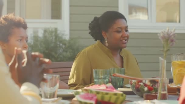 阳光明媚的日子 非裔美国人在屋外的院子里围坐在餐桌旁 手牵手祈祷 共进午餐 — 图库视频影像