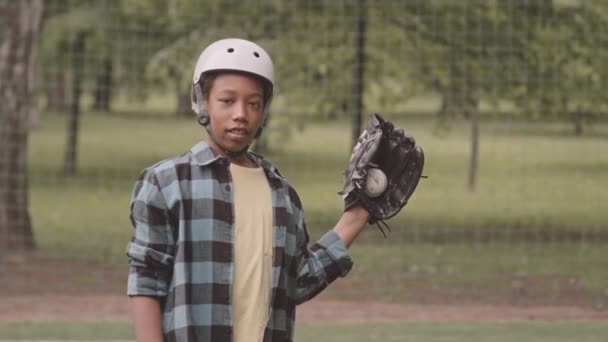 中肖像画中的非洲裔美国人12岁男孩站在公园外拿着棒球手套对着摄像机笑 — 图库视频影像