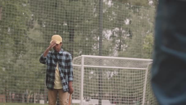 在公园接受教练户外运动训练的非洲裔美国少年男孩慢慢学会了打棒球 — 图库视频影像