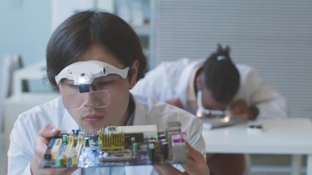 Asian Male Computer Engineer Wearing Headband Magnifier Examining Motherboard Laboratory — Stok video