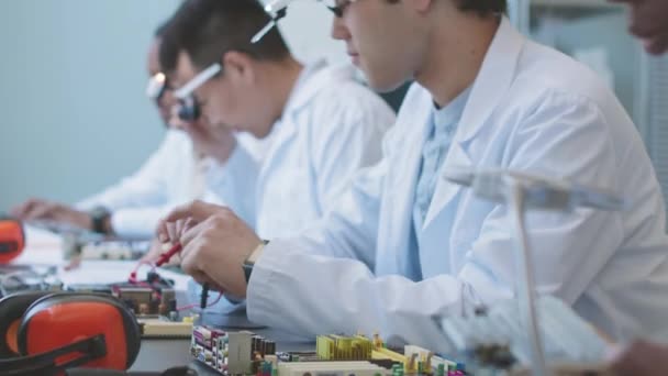 Group Multiethnic Computer Engineers Lab Coats Repairing Assembling Motherboards Sitting — Vídeo de Stock