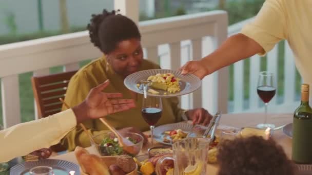 Woman Serving Dinner Family Members Sitting Table Cozy Summerhouse Evening — Video