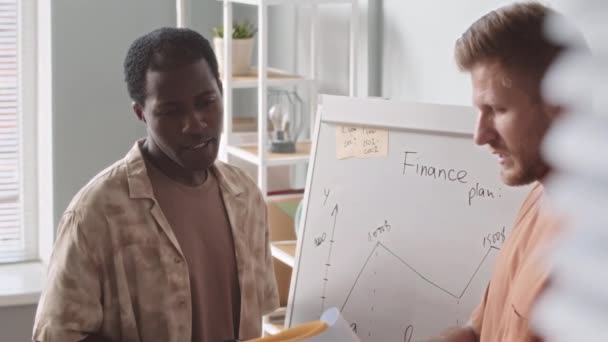 Medium Slowmo Two Young Multiethnic Startupers Drawing Finance Plan Whiteboard — Stock Video