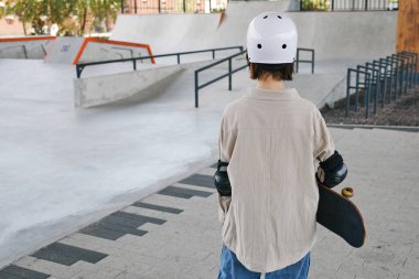 Dışarıdaki kaykay parkında koruma ve kask takan küçük bir kızın arka plan görüntüsü.