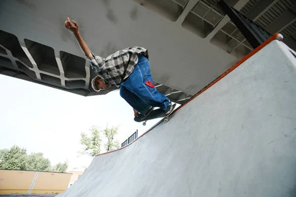 スケートボードに乗っている十代の少年と屋外スケートパークで空気中のトリックを行う — ストック写真