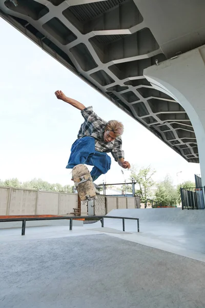 Pionowy Portret Nastolatka Wykonującego Triki Deskorolkowe Powietrzu Skateparku Świeżym Powietrzu — Zdjęcie stockowe
