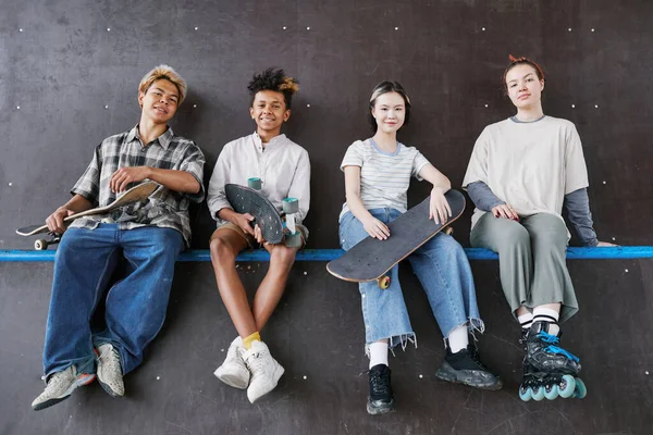 Minimalne Ujęcie Różnorodnej Grupy Nastolatków Patrzących Kamerę Siedzącej Rampie Skateboardingu — Zdjęcie stockowe