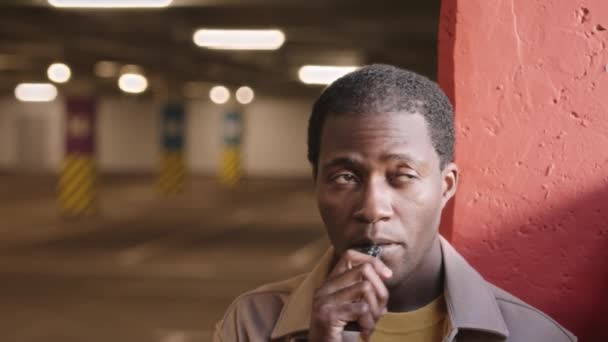 Medium Closeup Black Man Smoking Electronic Cigarette Looking Standing Dark — Stockvideo