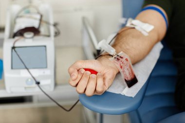Kan bağışı merkezinde kan verirken, bir erkeğin stres topunu sıkarken yakın plan, boşluğu kopyala
