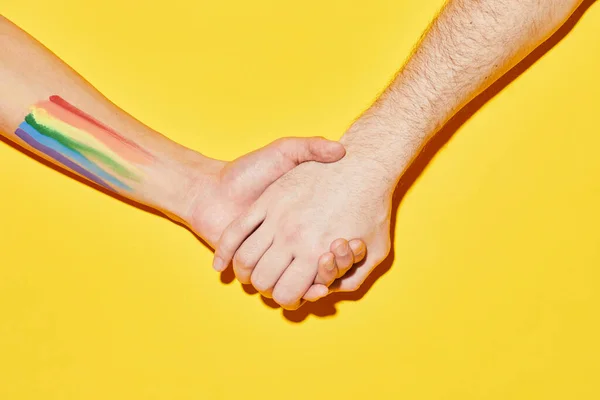 Wibrujące Ujęcie Dwóch Osób Trzymających Się Ręce Tatuażem Flagi Lgbt — Zdjęcie stockowe
