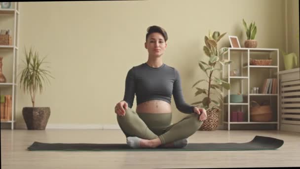 Slowmo Portrait Young Pregnant Woman Tight Activewear Sitting Lotus Pose — стоковое видео