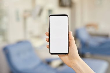 Kan bağışı merkezinde boş ekranlı akıllı telefonu tutan kadın elini kapat, boşluğu kopyala