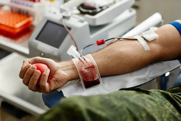 闭合无法辨认的男性捐献者献血和挤压压力球 复制空间 — 图库照片