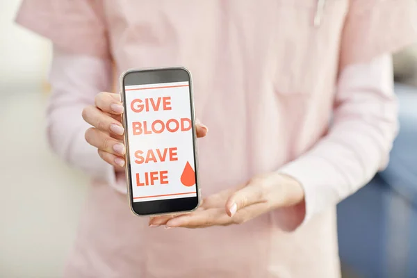 临近女护士手持智能手机在献血中心献血救人口号 复制空间 — 图库照片