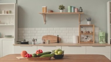 No people shot of contemporary kitchen interior in white colors with wooden table and shelves