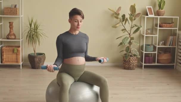 Energetic Young Pregnant Woman Exercising Dumbbells While Sitting Fit Ball — Vídeos de Stock