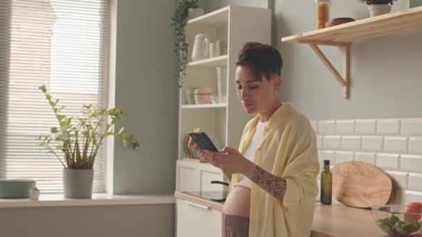 Medium Shot Cheerful Young Pregnant Woman Eating Apple Texting Friends — Αρχείο Βίντεο