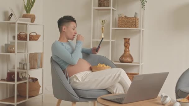 Young Caucasian Pregnant Woman Short Haircut Eating Junk Food While — Stockvideo