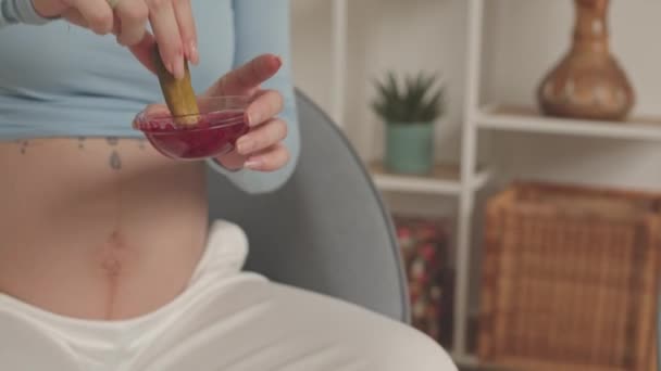 Modern Pregnant Woman Headphones Eating Pickles Jam While Watching Film — стоковое видео