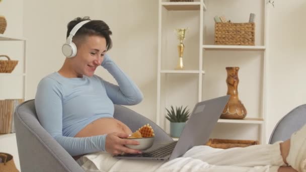 Young Pregnant Woman Smiling While Watching Film Laptop Headphones Home — Wideo stockowe