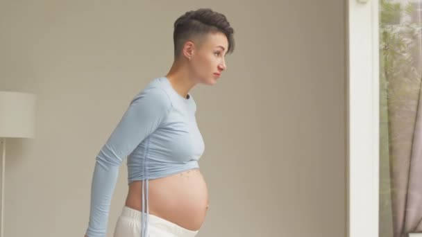 Medium Shot Short Haired Young Pregnant Woman Measuring Her Tummy — 图库视频影像