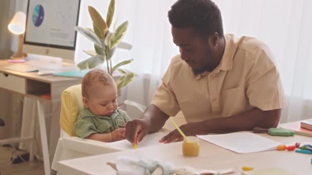 Fürsorglicher Afroamerikanischer Vater Putzt Hochstuhl Nachdem Seinen Niedlichen Kleinen Sohn — Stockvideo