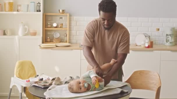 Pai Afro Americano Feliz Mudando Fralda Para Seu Filho Bebê — Vídeo de Stock