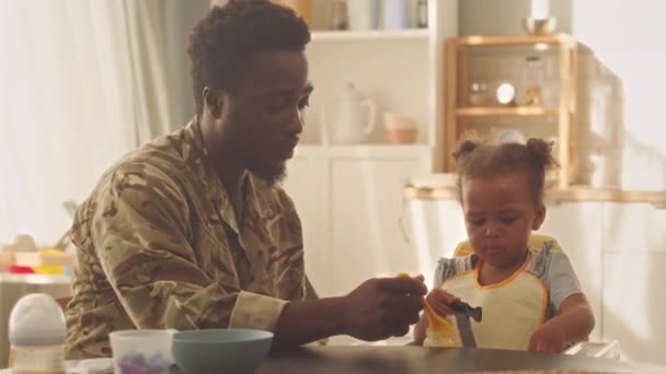 Junger Afroamerikaner Füttert Seine Freche Kleinkind Tochter Hause Mit Babybrei — Stockvideo