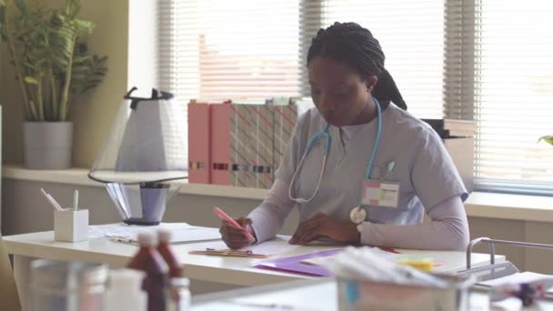 Ung Afroamerikansk Kvinnlig Veterinär Buskar Och Stetoskop Runt Halsen Sitter — Stockvideo