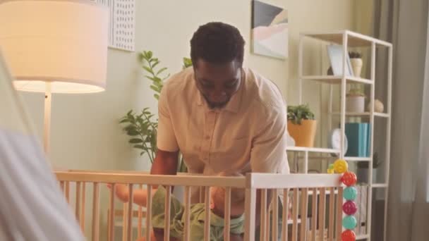 Afro Amerikaanse Man Zet Zijn Schattige Baby Zoon Thuis Slapen — Stockvideo