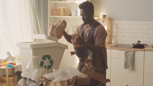 Hombre Afroamericano Con Hijo Bebé Portador Clasificando Basura Casa Para — Vídeos de Stock
