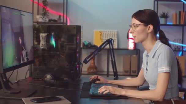 マウスとキーボードを使用してPcでFpsゲームをしている彼女の初期の20代の集中白人少女のミディアムショット — ストック動画