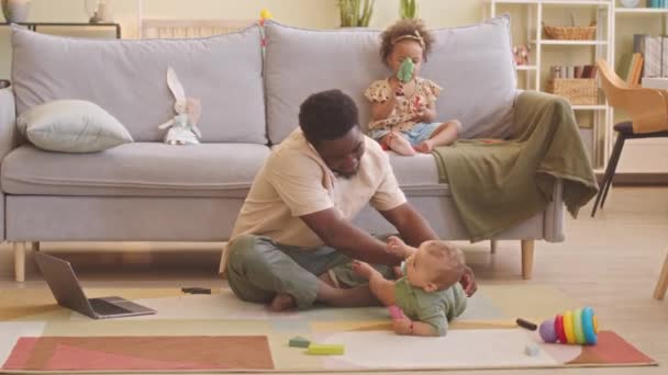 Junger Afroamerikaner Wechselt Seinem Einjährigen Sohn Die Windel Während Hause — Stockvideo
