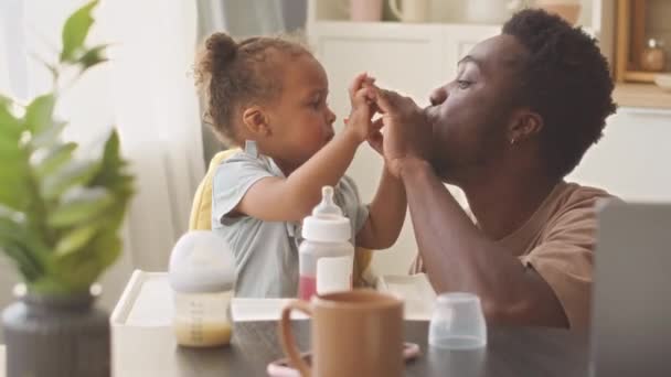 Cheerful Young Black Man Feeding His Naughty Toddler Daughter Sitting — Stock Video