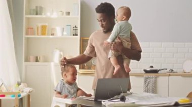 Afrikalı Amerikalı baba, iki küçük çocuğuna bakıyor. Evde yalnız kalıyor.