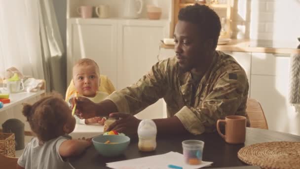 Jovem Afro Americano Alimentando Seus Dois Filhos Pequenos Sentados Juntos — Vídeo de Stock
