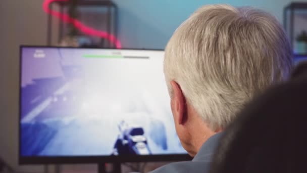 灰色头发的男人坐在电脑前玩Fps游戏时使用鼠标和键盘 — 图库视频影像