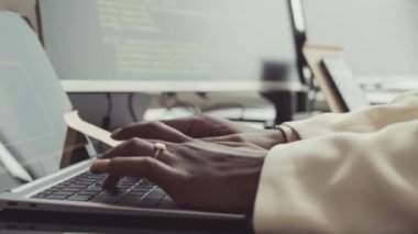 Ofisteki dizüstü bilgisayarında programlama kodları yazan tanınamayan Afro-Amerikan kadın programcının yavaş yavaş el ele tutuşması.