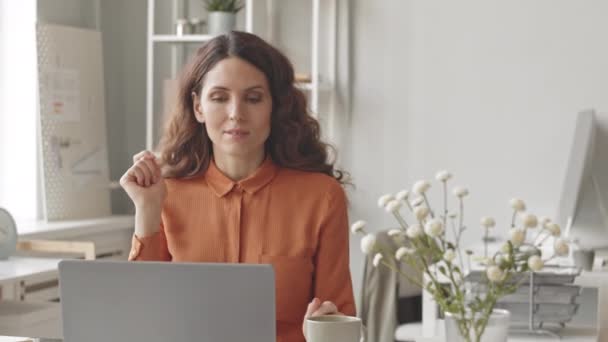 Młoda Wymarzona Bizneswoman Korzystająca Filiżanki Kawy Podczas Pracy Laptopie Jasnym — Wideo stockowe