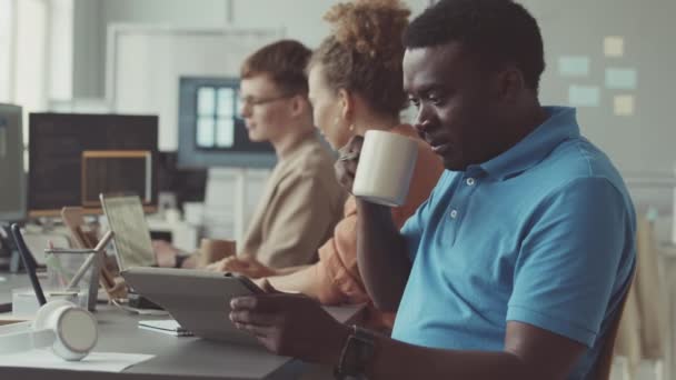 Jeune Homme Noir Utilisant Une Tablette Numérique Tout Travaillant Dans — Video