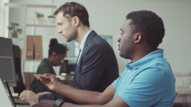 2人の多様な男性ソフトウェアエンジニアがコンピュータ上でコーディングし 話し合い 現代のIt企業で協力するスローモーションを待つ — ストック動画