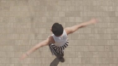 Yüksek açılı Vogue dansçısının klasik kıyafetli hali. Dönüyor ve açık havada daldırıyor.