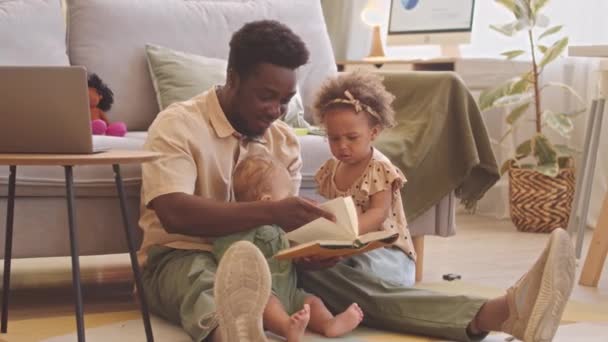 Afroamerikanischer Mann Liest Seinem Kleinen Sohn Und Seiner Tochter Buch — Stockvideo
