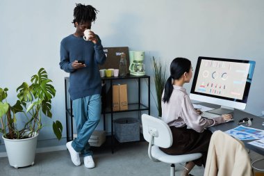 Şirket ofisinde çalışan ve çalışan çeşitli takımların portresi, teneffüste kahve içen siyah genç adama odaklan, boşluğu kopyala