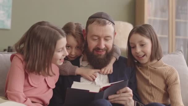 Judisk Far Läser Haggadah För Sina Tre Små Döttrar Firar — Stockvideo