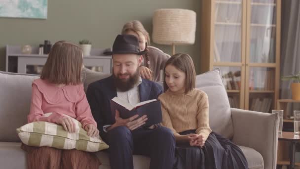 Еврей Читает Танах Своим Трем Дочерям Хануке Празднуя Дома — стоковое видео