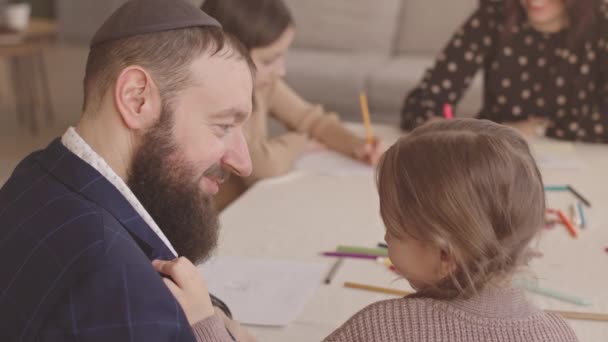유대인 아버지와 집에서 가족과 하누카에 엽서를 그리는 솔직한 미소로 서로를보고 — 비디오